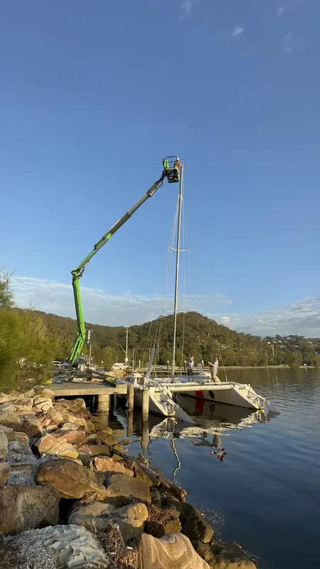 EWP working on yacht mast at waterfront